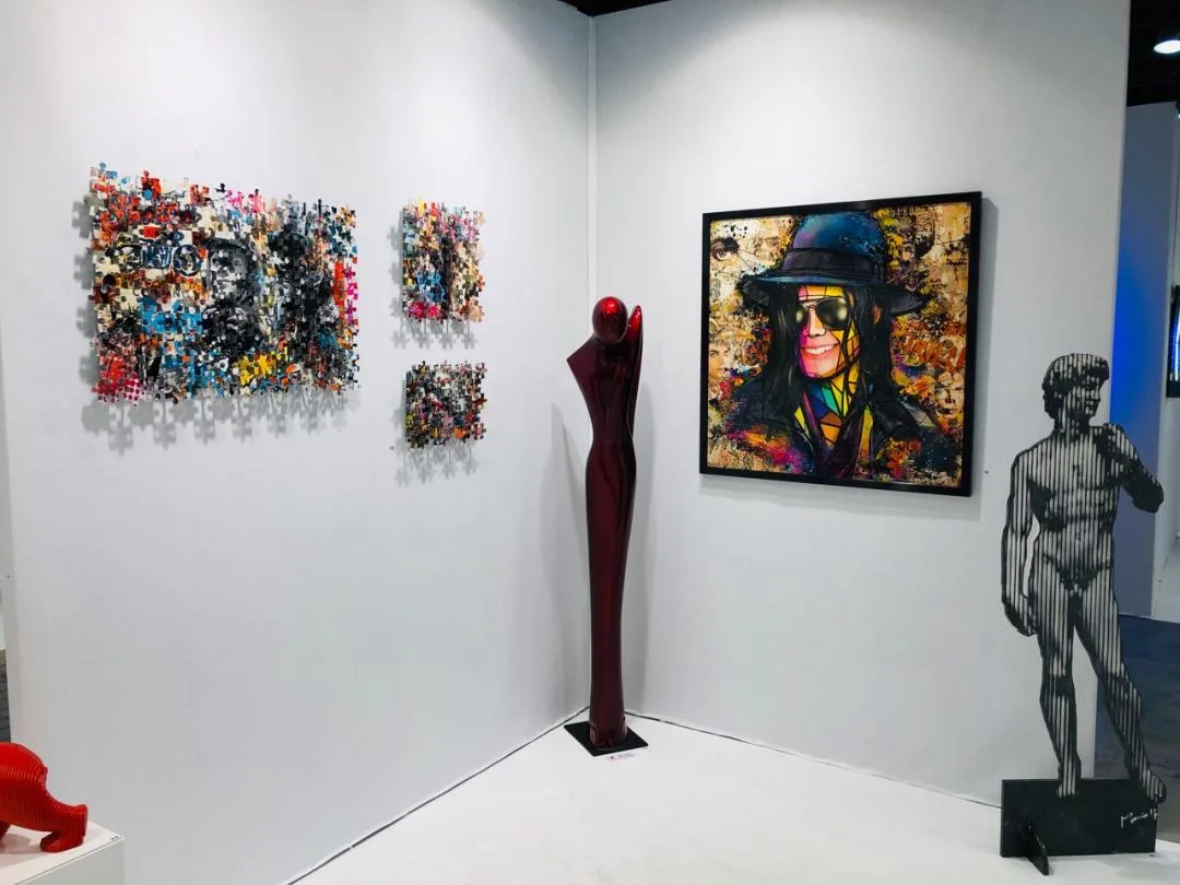 Stand d'exposition avec plusieurs œuvres de Melvyn Barros : portraits, tableaux en puzzle et sculptures